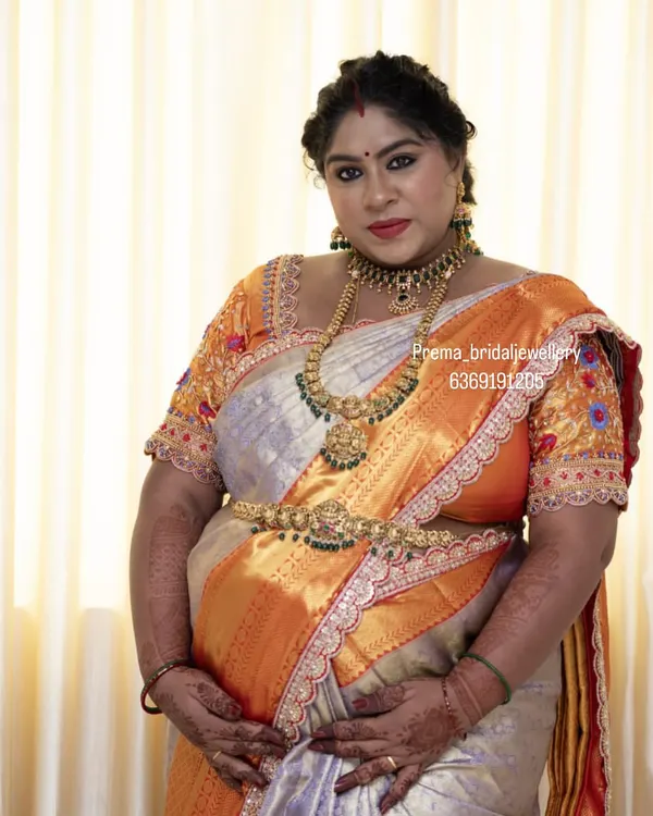 This mom-to-be is glowing at her baby shower. She chose a beautiful antique temple jewellery set, including a choker, haaram, and vaddanam, to celebrate this special day.
