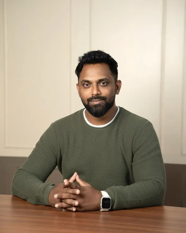 This professional headshot is framed to convey authority and thoughtfulness. The subject is seated at a desk, which adds a corporate context, while the lighting is designed to be flattering yet strong, perfect for an entrepreneur or executive.