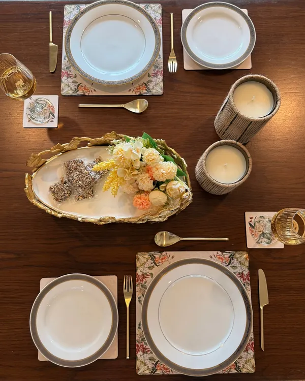 We styled this intimate table for two to turn a simple meal into a shared memory. The setting features our floral placemats, marble coasters, and a gold-leafed serving platter, proving that hosting is in the little moments too.