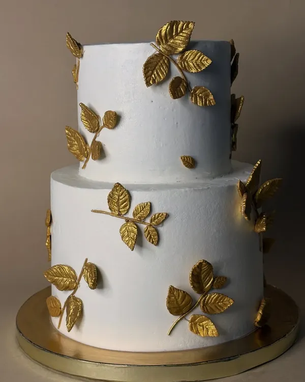 This two-tiered cake with delicate, hand-painted golden leaves is a testament to simple elegance. It was a humbling experience working with fondant to create this clean, minimalist design for a very special couple.