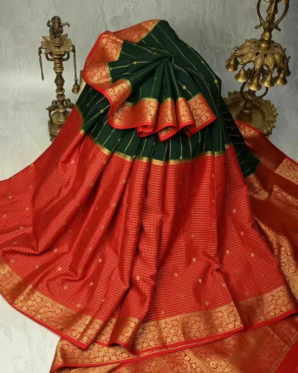 A classic Kanjivaram in a stunning combination of bottle green and red. The body features delicate gold checks, while the wide zari border adds a touch of bridal grandeur. This is a timeless piece for any silk connoisseur.