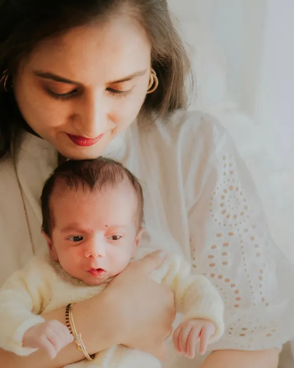 A mother looks down at her newborn with pure adoration. This in-home session captures the quiet, beautiful reality of the first few days with a new baby.