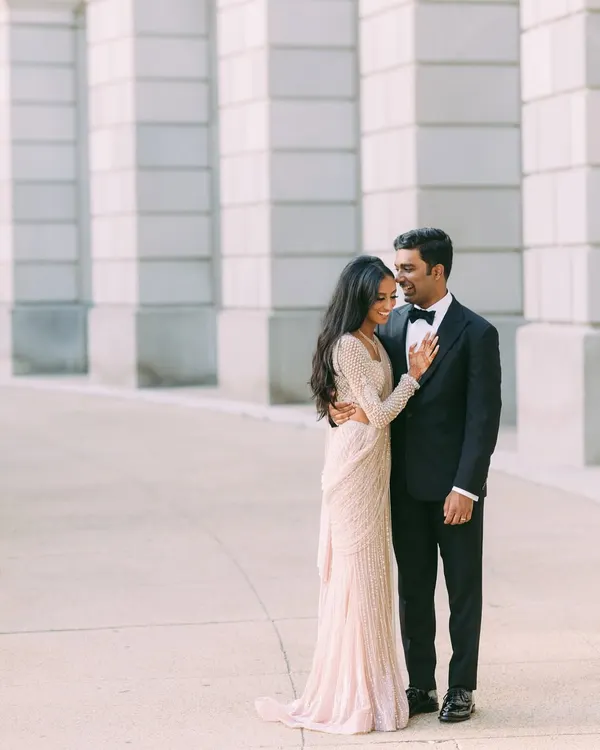 The perfect modern couple look for a party. Nisha is elegant in a shimmering Falguni Shane Peacock sari, and Vishal is sharp in a classic tuxedo from Amaare. They are ready for their grand entrance.