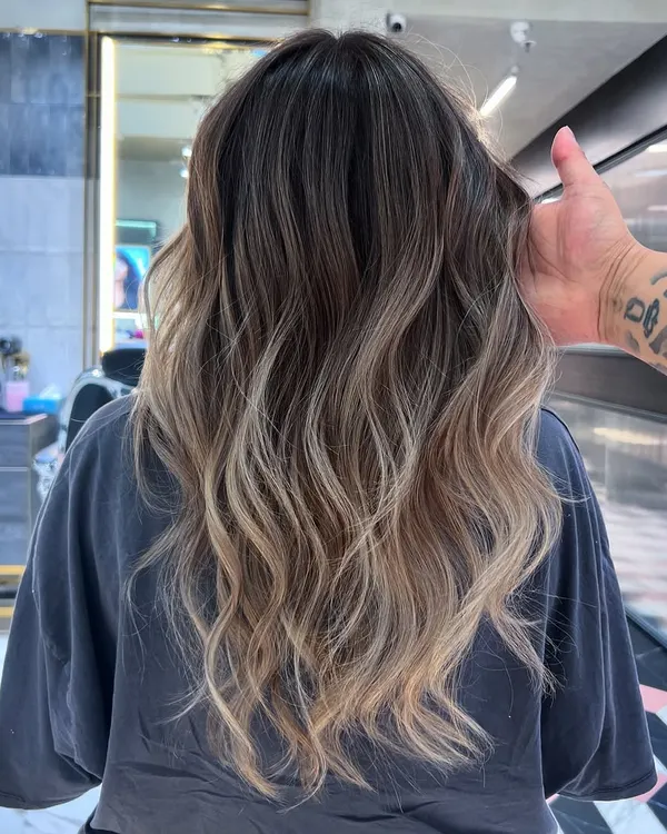 This is a beautiful example of an ash-blonde balayage. I used Redken 09T and 09B to create this cool, smoky transition from a natural dark root to light, wavy ends.