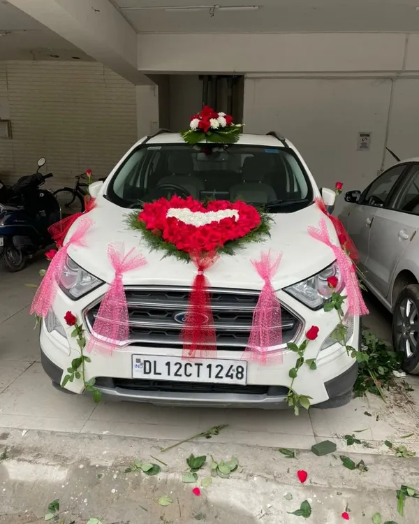 A popular design for a wedding car featuring a heart made of red roses on the bonnet. The look is completed with red and pink ribbons, making the car look festive and ready for the baraat.