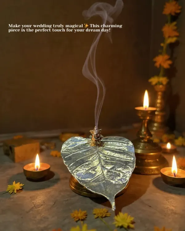 Add a touch of magic to your wedding rituals with this charming peepal leaf incense holder. The smoke gracefully rises from the leaf, creating a serene and divine atmosphere for your pooja.