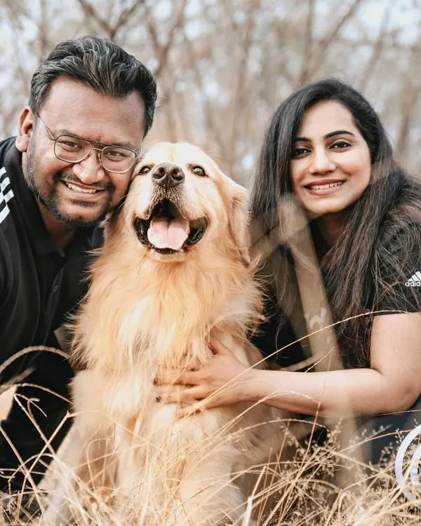 A beautiful family portrait in a field of golden grass. The genuine smiles on everyone's faces, including Archie the golden retriever, say it all.