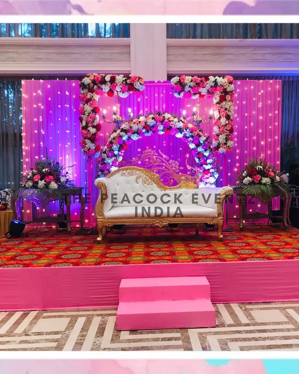 For this Roka ceremony, I designed a stage with a baby pink backdrop, twinkling fairy lights, and a floral arch accented with a chandelier to give the event a royal and romantic feel.