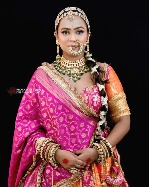 A queen stepping into her era of love. This look features a vibrant pink and orange lehenga, complemented by makeup that is both bold and graceful, with a focus on glowing skin.