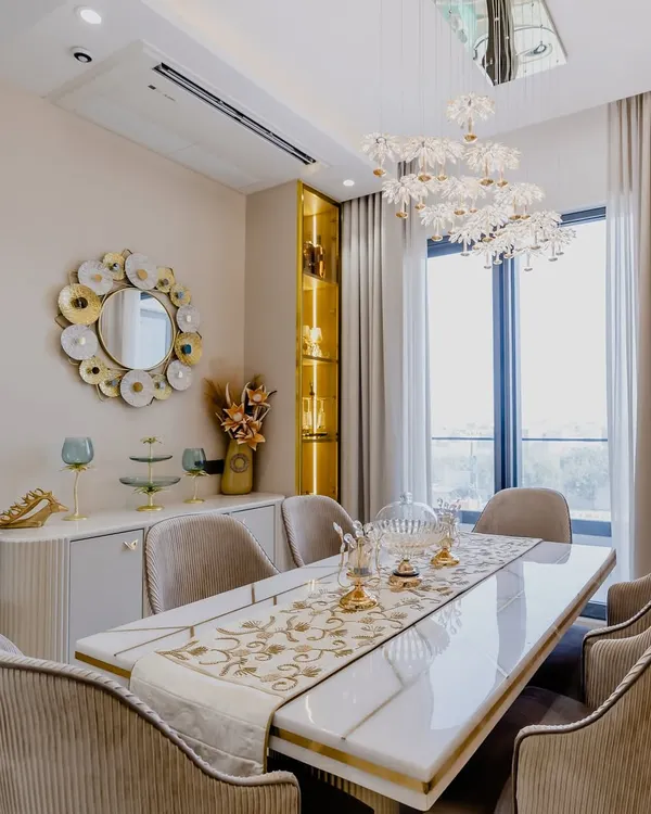 This luxurious dining area is perfect for hosting. The stunning floral chandelier, gold-accented mirror, and plush velvet chairs create an atmosphere of pure elegance. Every meal here feels like a celebration.