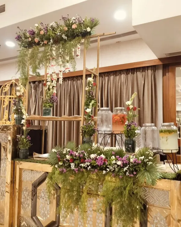 My detox water station is a beautiful addition to any event, featuring glass dispensers with fresh fruits and herbs, and decorated with lush greenery.