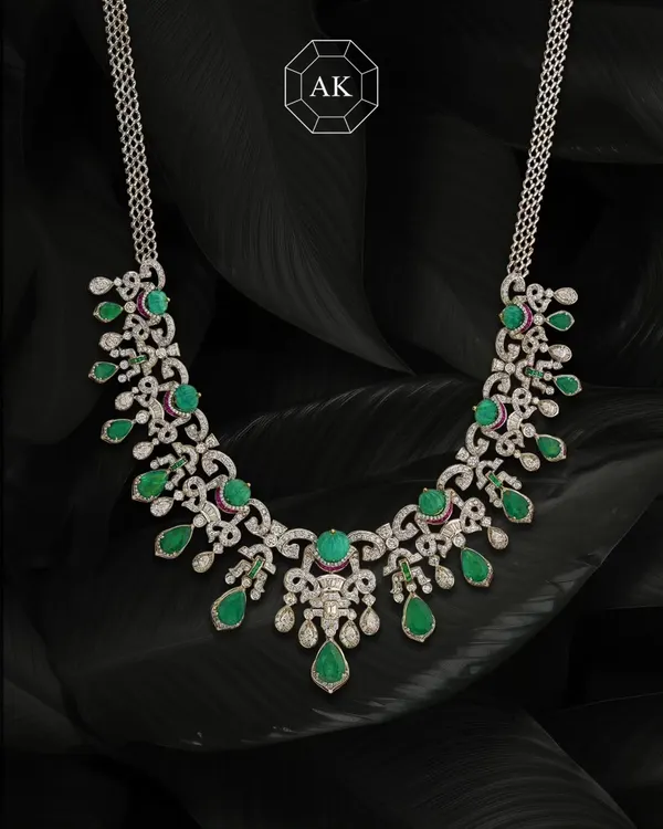Where tradition meets bold design. This striking necklace blends two shades of natural Zambian emeralds with round and baguette diamonds, accented with a hint of ruby. It's handcrafted with a modern touch, perfect for carrying culture with style.