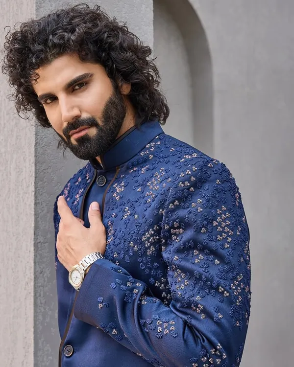 A close-up of this navy blue bandhgala reveals the subtle, geometric hand-embroidery. It's a perfect example of understated luxury, designed for the discerning gentleman.
