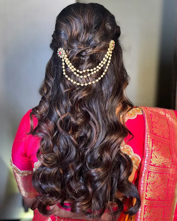 A beautiful half-up, half-down hairstyle with soft curls for my Gujarati bride. The delicate hair accessory adds a touch of elegance and completes the romantic look.