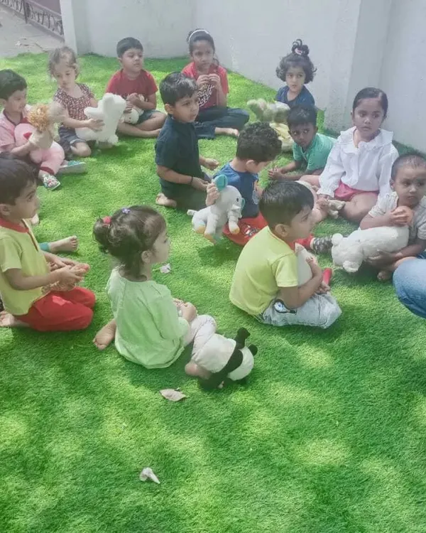Our Summer Fun Fest is all about joy and discovery. Here, children are gathered for a group activity, sharing stories and making friends in a relaxed, happy atmosphere.