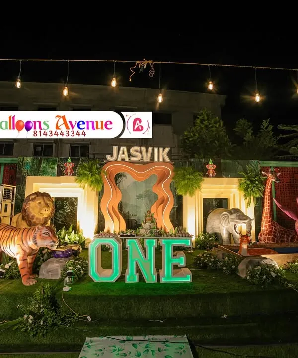 This is what we mean by a grand celebration. For this first birthday, we created a massive outdoor jungle theme, complete with life-sized animal props, extensive greenery, custom marquee letters, and dramatic night lighting to make the entire venue feel like a different world.