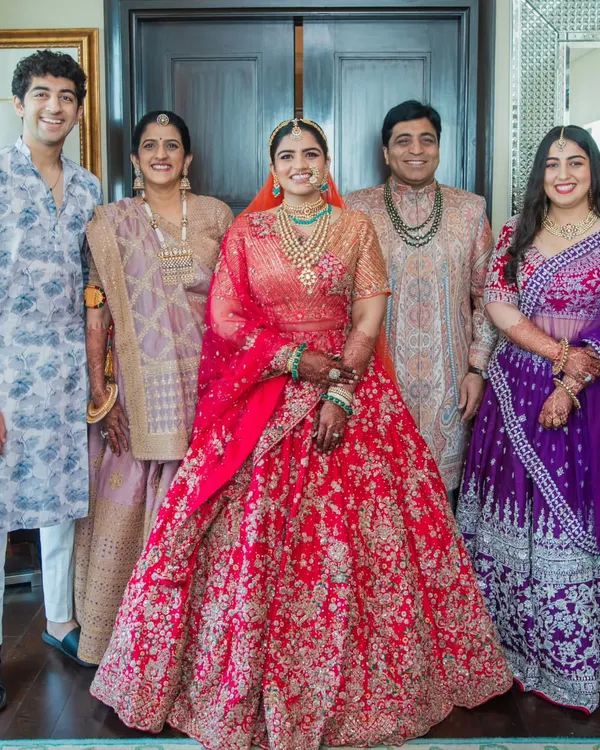 A beautiful portrait of the bride with her entire family. I worked with each person to create a look that reflected their personal style while coordinating with the bride's magnificent red lehenga. The result is a harmonious and elegant family picture.
