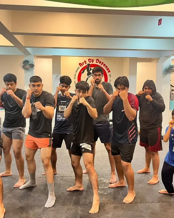 Hands up, chin down. A group of our members, a mix of teens and adults, hold their fighting stance for a team photo after a demanding training session.