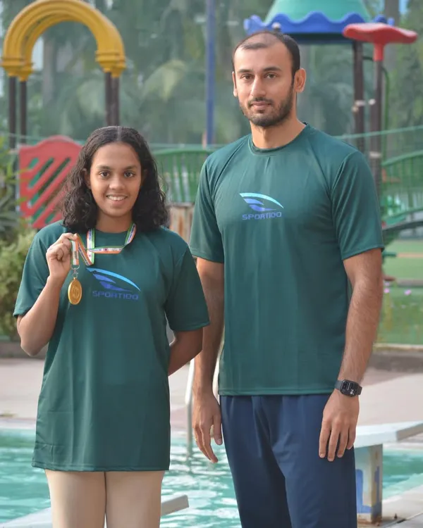 Head Coach Virdhawal Khade stands with national gold medalist Nirmayee Ambetkar. Direct mentorship from an Olympian is a key part of our program's success.