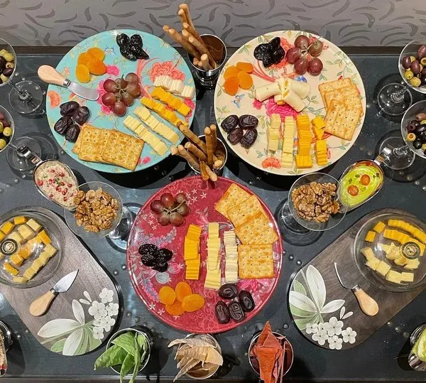 A vibrant and abundant European-style grazing platter. These are perfect for cocktail hours, featuring an assortment of artisanal cheeses, cured meats, fresh fruits, crackers, and nuts.