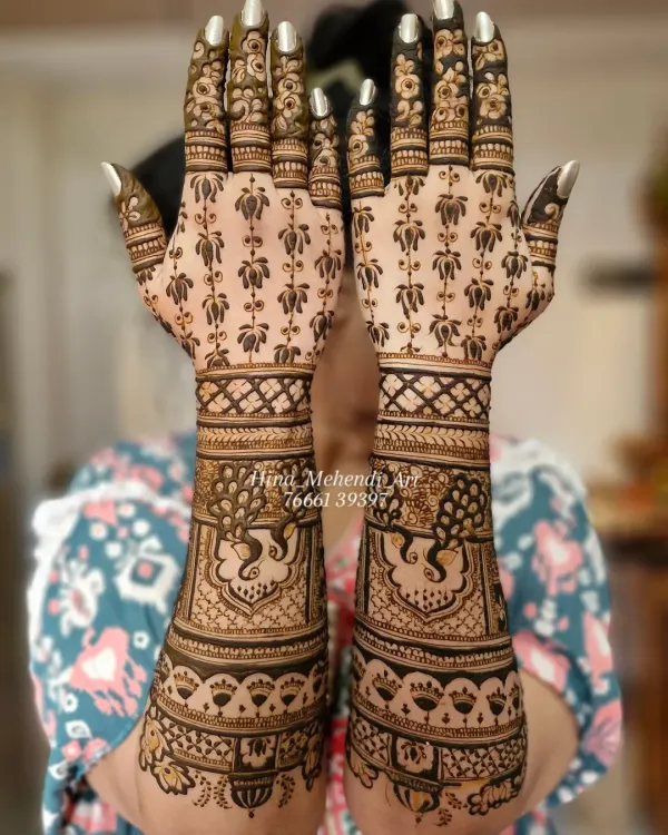 A beautiful example of full-coverage Indian bridal mehendi. This design features elegant peacocks on the wrists and a delicate floral pattern extending to the fingertips.