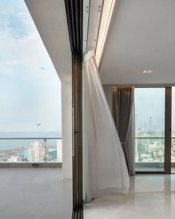 For this Mumbai penthouse, the design is intentionally minimal to let the stunning sea view take center stage. The open, clutter-free space and the gentle breeze animating the curtains create a tranquil retreat high above the city.