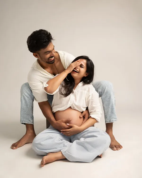 A playful and intimate moment. This candid shot captures genuine laughter and connection, showcasing a modern and relaxed approach to maternity photography.