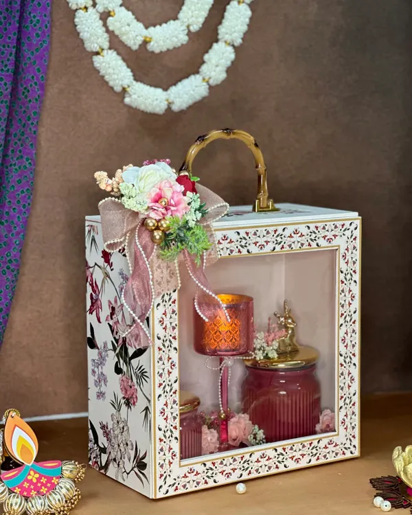 This exquisite hamper is a true style statement for your Diwali gifting. The elegant box with a window display contains a lit candle and beautiful jars, making it a luxurious and practical gift that also complements home decor.