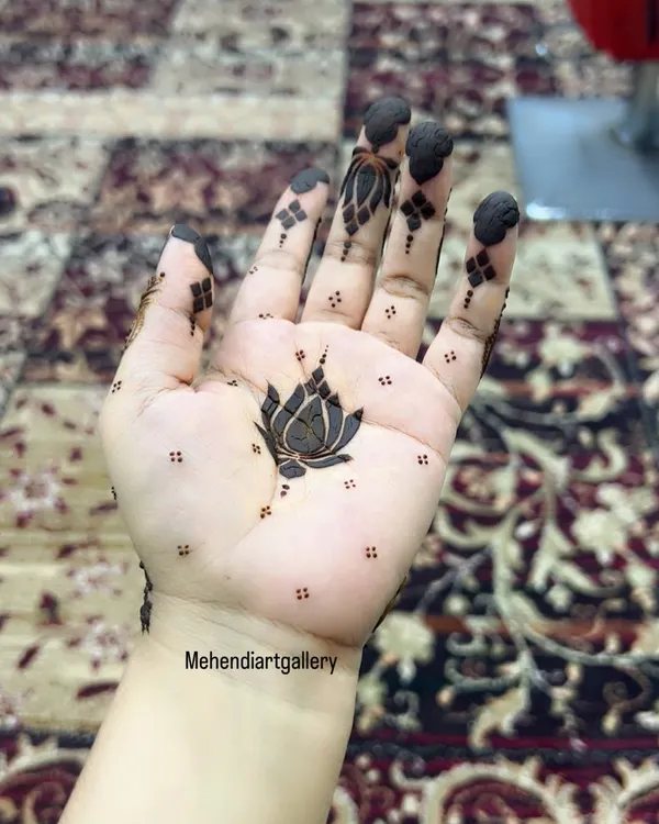 A simple yet elegant lotus motif in the center of the palm. This minimalist design is perfect for someone who wants a small but meaningful piece of henna art.