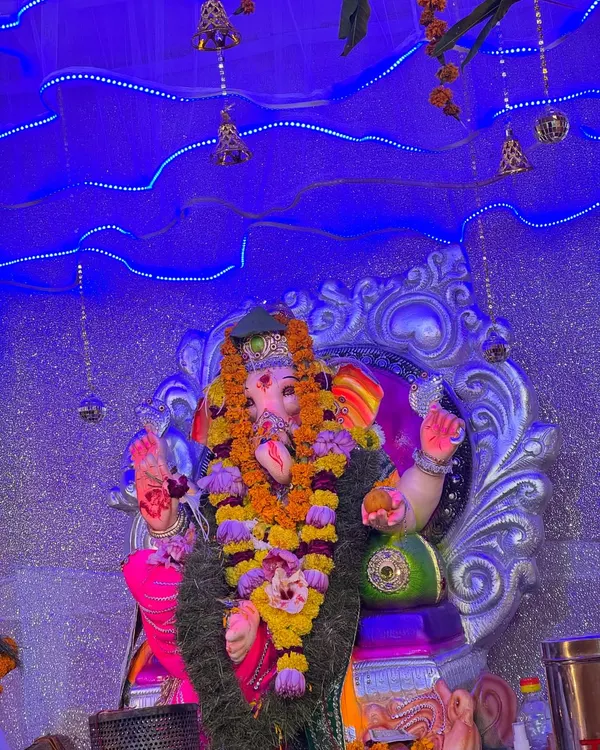 A close-up of a Ganpati idol, with my custom lighting setup in the background. I use blue LED lights and hanging bells to create a divine and serene atmosphere for the puja.