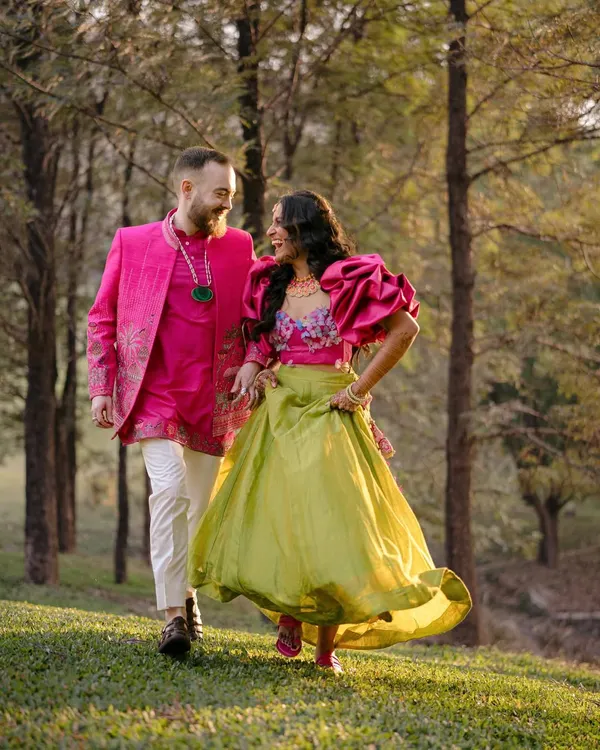 Ben and Shrutika, walking through a sun-dappled forest. Their vibrant outfits and shared laughter create a portrait that is full of life and movement, a perfect reflection of their joyful connection.