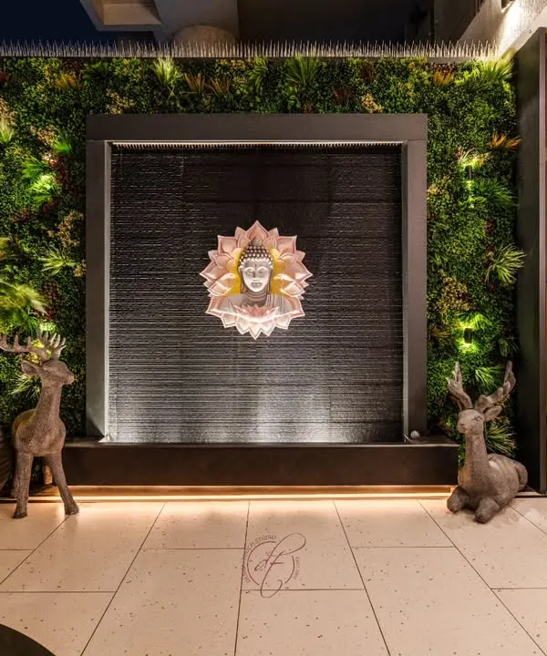 This serene terrace corner features a custom water wall with a Buddha centerpiece, framed by a lush vertical garden. The deer sculptures and warm uplighting create a peaceful and artistic ambiance.