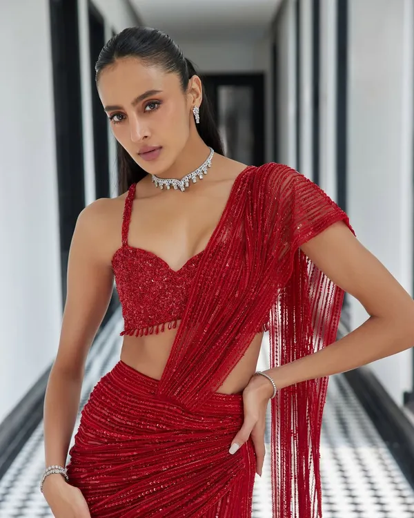 This show-stopping red drape saree from the Élan ‘24 collection is the epitome of modern glamour. The fluid drape, daring slit, and embellished bustier are designed for the woman who owns the room.