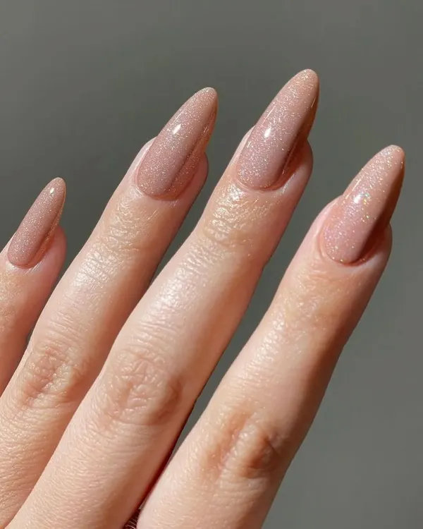 A beautiful and elegant set of long stiletto nails in a shimmering nude gel polish. This color has a subtle glitter that catches the light perfectly.