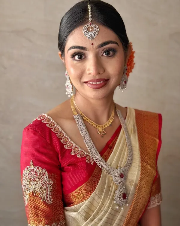 This is the look that is closest to my heart. For Jahnavi's muhurtham, we created a classic South Indian bridal look with glowing skin, defined eyes, and a bold lip to perfectly complement her red and cream Kanchipuram saree. Her radiant smile says it all.