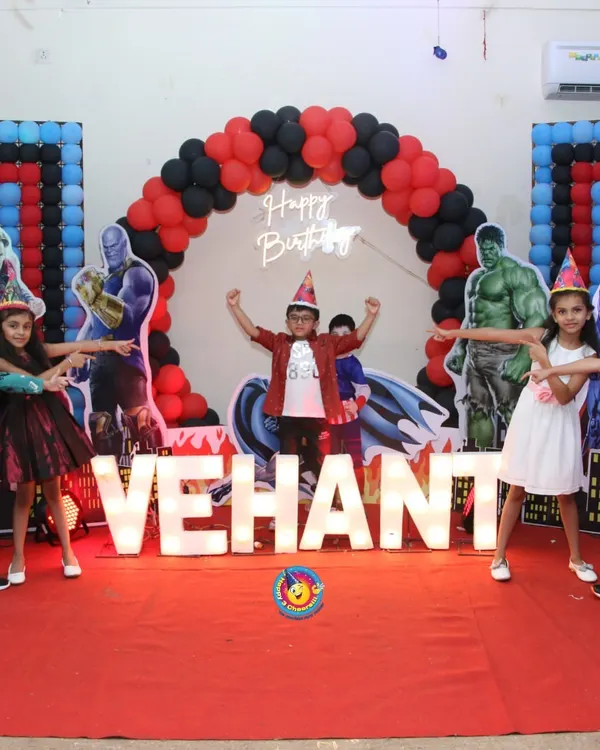 This Avengers-themed party for Vehant was all about assembling the heroes. The stage featured a red carpet, large marquee letters spelling his name, and life-sized cutouts of characters like Hulk and Superman against a balloon arch.