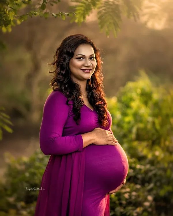 Bathed in the warm glow of the setting sun, this mother-to-be radiates pure joy. The golden hour light in this outdoor portrait perfectly highlights her beautiful baby bump and happy smile.
