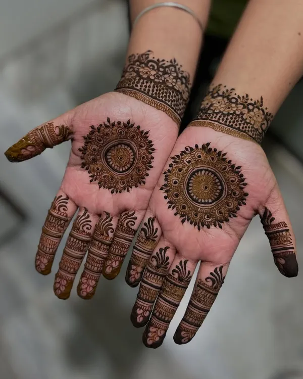A sweet and simple design featuring a beautiful mandala in the center of each palm. The fingers are decorated with complementary patterns for a balanced and elegant look.