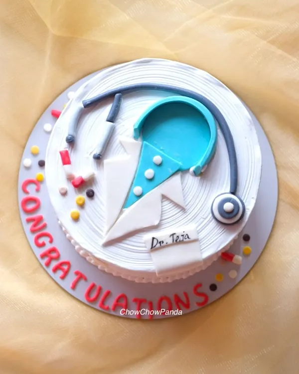 A top-down view of the doctor-themed cake, showing the handcrafted stethoscope, pills, and doctor's coat details. This was a Truffle with Ferrero Rocher cake.
