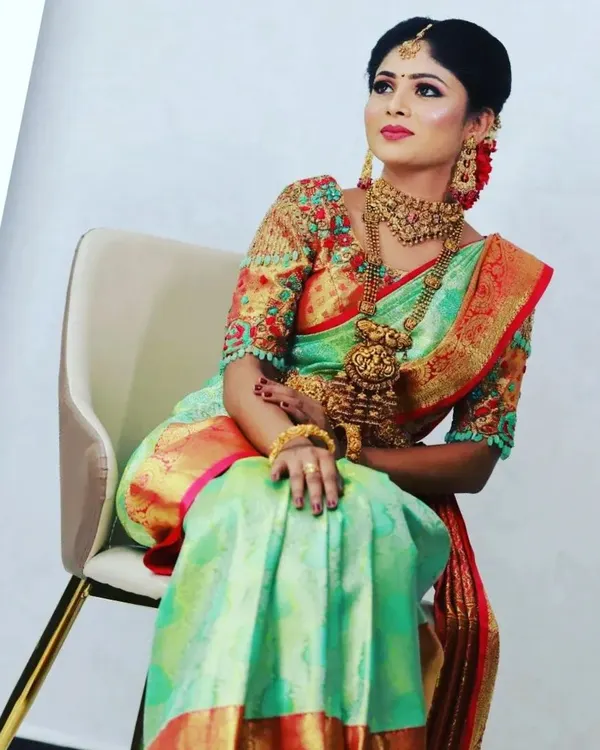 A stunning shot from a jewellery marketing campaign. The model is wearing a beautiful Kanchipuram half-saree, and the makeup is designed to be bold and glamorous to complement the intricate jewellery.