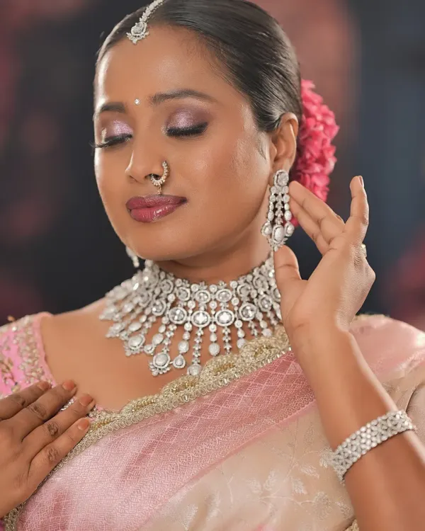 A beautiful close-up of a soft glam look on a dusky-skinned bride. The pink and silver tones of the makeup and jewelry create a stunning, ethereal glow.