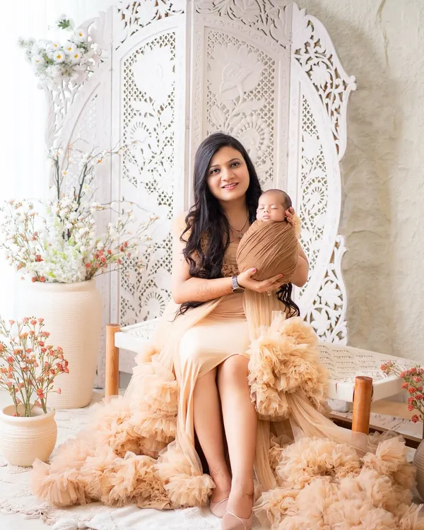 A serene portrait of a new mother holding her swaddled newborn. I use soft, neutral-toned wraps to keep the focus on the baby's delicate features.