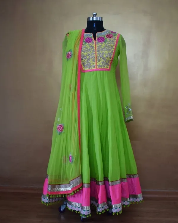 This full-length view shows the beautiful flare of the neon green Anarkali. The combination of the bright color, floral embroidery, and gota patti border makes it a truly standout piece for any festive occasion.