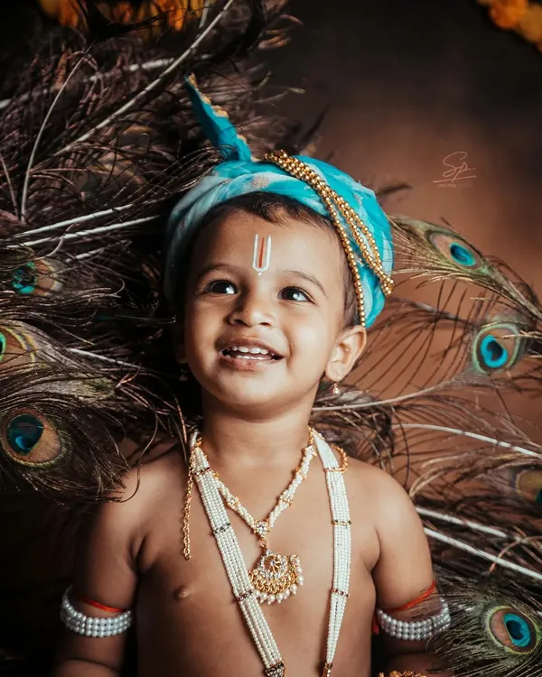 The innocent, upward glance of our little Krishna, framed by peacock feathers. This portrait highlights the detailed styling, from the turban to the pearl necklaces, that makes my themed shoots so special.