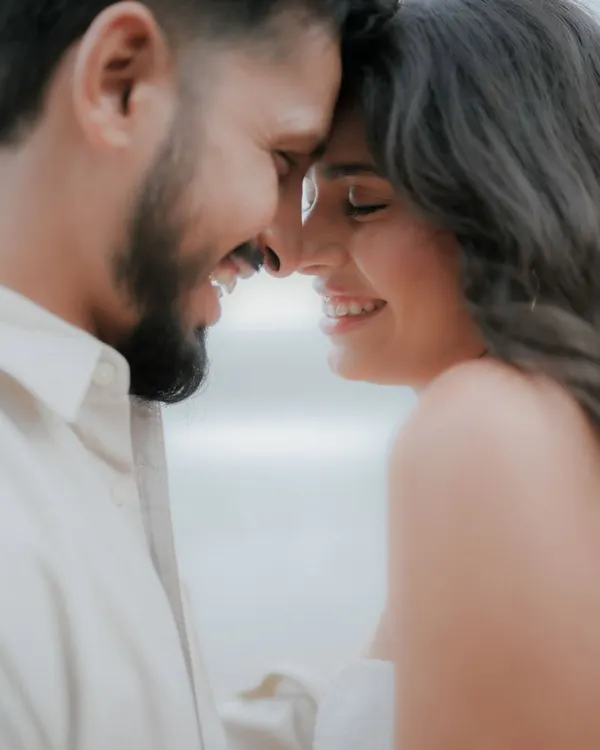 A close-up of a couple's happy, smiling faces as they touch foreheads. This candid portrait captures a moment of pure joy and affection, a signature of our couple photography style.