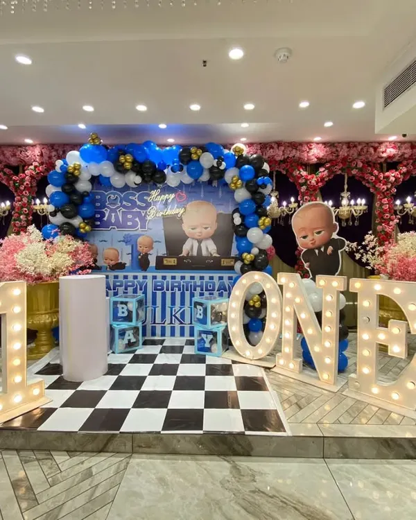 This is how I bring the popular 'Boss Baby' theme to life for a grand first birthday. The setup includes large marquee letters for the age, a custom backdrop with characters, a balloon arch in the theme's colors, and character cutouts to create a complete, immersive experience for your little one's big day.