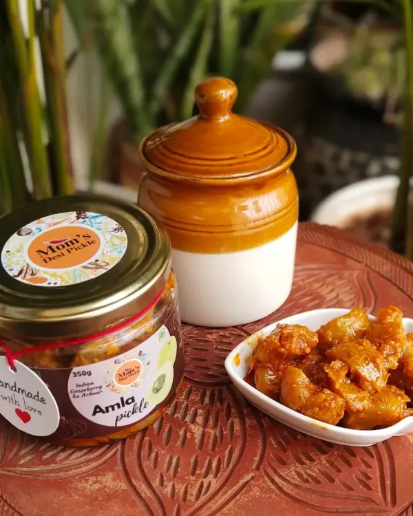 This is our Amla Pickle, handmade with love. We've served it here next to a traditional ceramic 'martban' to show you that while our packaging is new, the recipe is as old and authentic as ever.