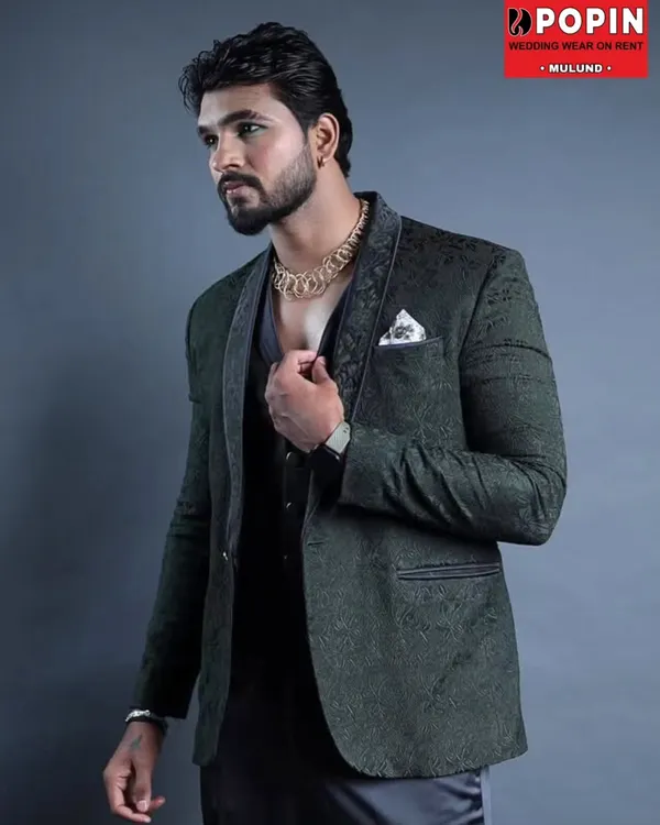 This dark green three-piece suit features a subtle, textured pattern and a contrasting lapel. It's a sophisticated and modern choice for a reception or formal party.