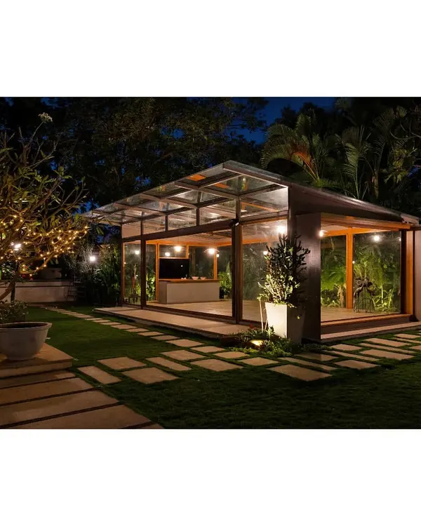The Komorebi Pavilion, a glass sanctuary nestled in a lush Bangalore garden. We designed this space to capture 'Komorebi', the Japanese term for the dappled light filtering through trees, creating a living pattern of light and shadow that connects the interior with the surrounding nature.