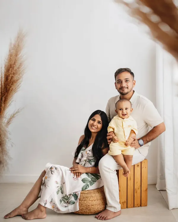 A first birthday portrait in my boho studio setup. The natural wood and pampas grass complement the family's neutral outfits perfectly.